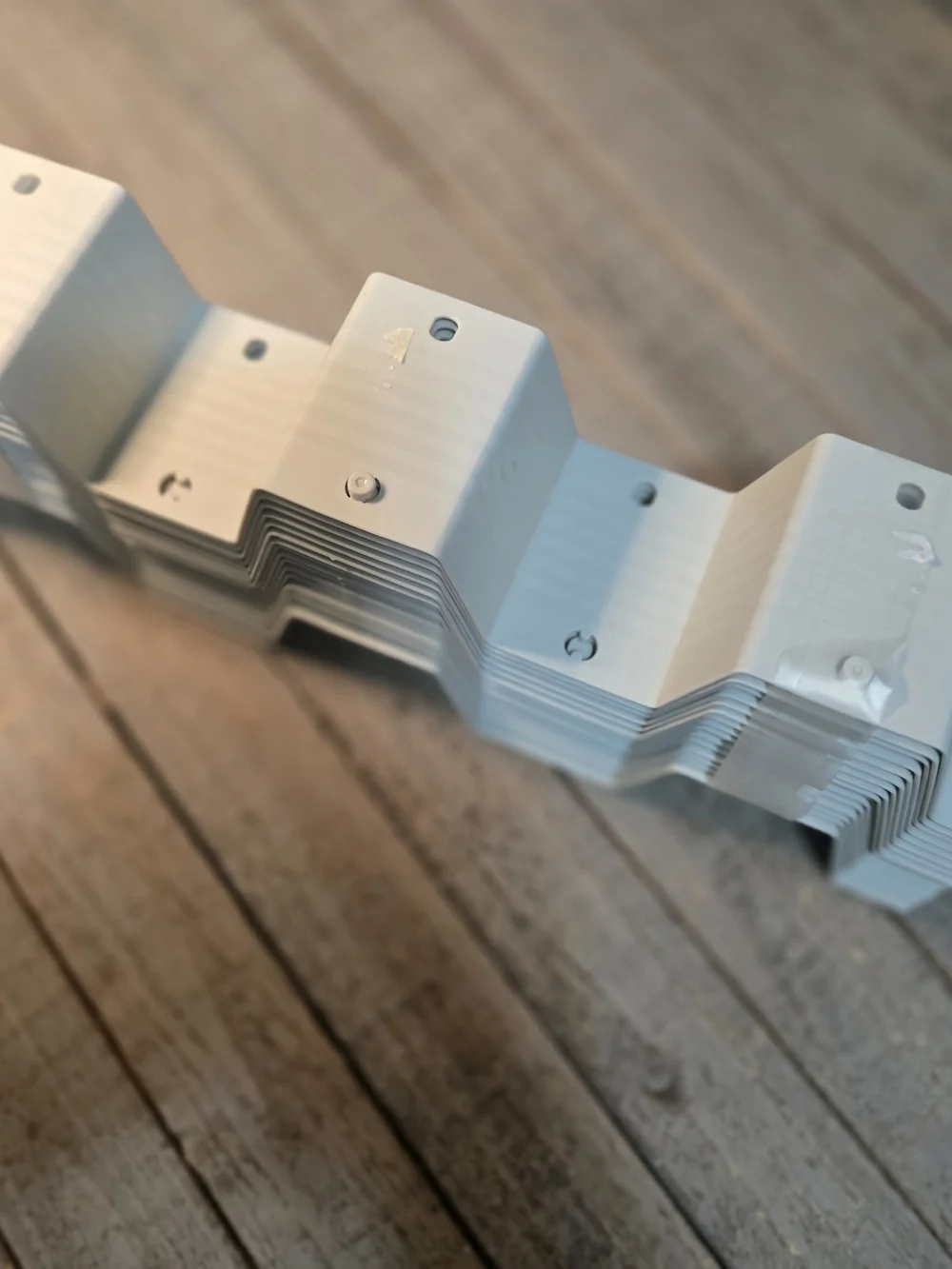 Stack of plastic honeycomb drawer divider panels in a light grey color.